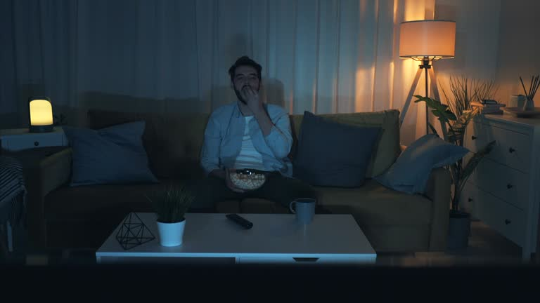 Person watching TV with popcorn